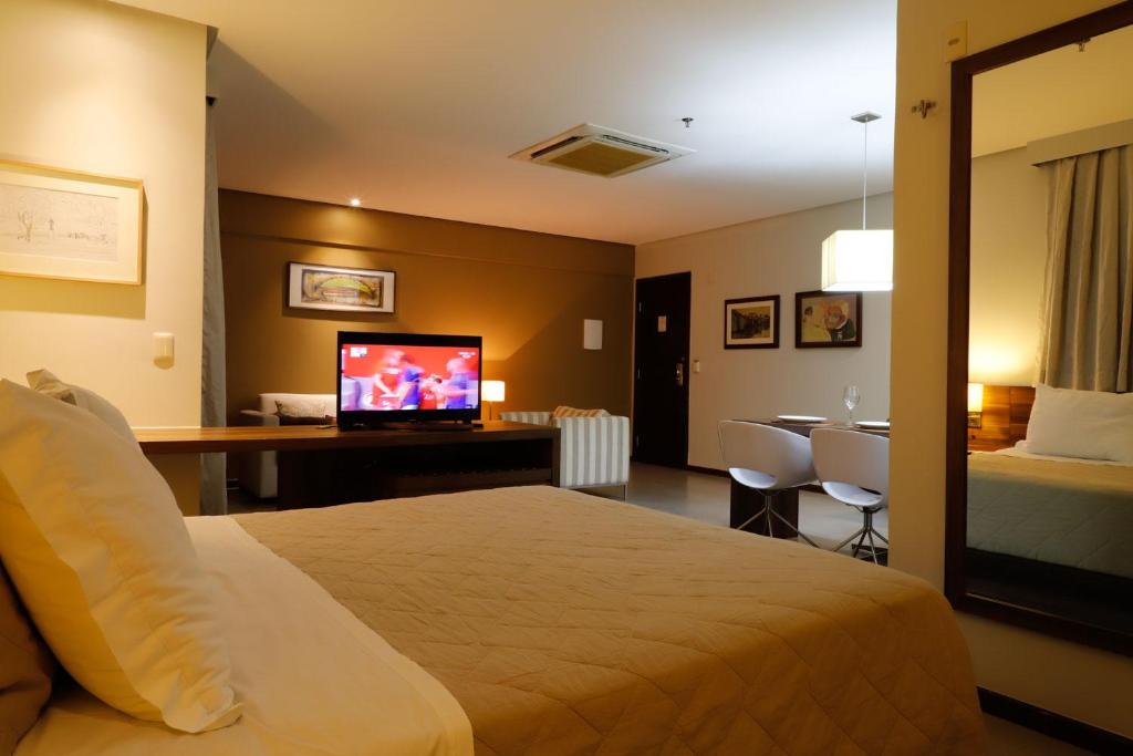 um quarto de hotel com uma cama e uma televisão de ecrã plano em Sofisticado Loft Mobiliado no Coração do Umarizal em Belém