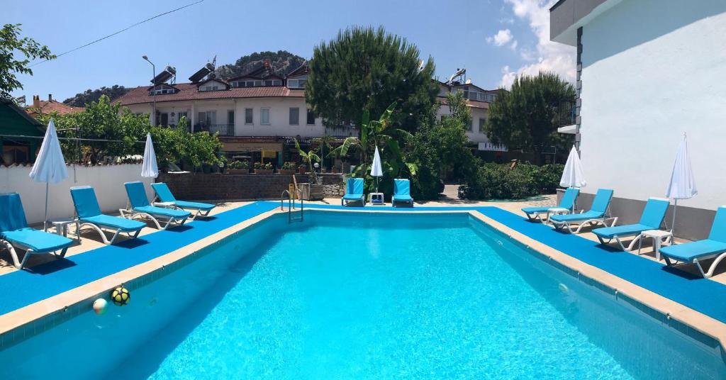 a swimming pool with lounge chairs and a hotel at Moonlight Apart Hotel in Dalyan
