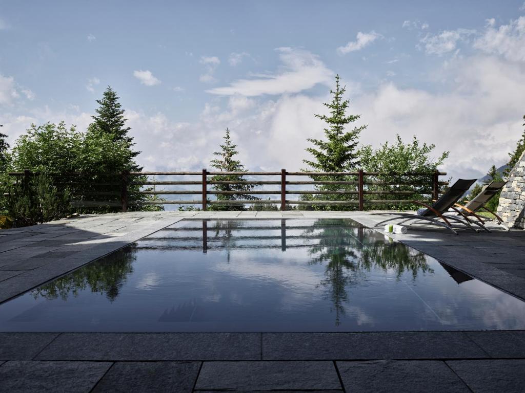 una piscina de agua en un patio con una valla en LeCrans, en Crans-Montana