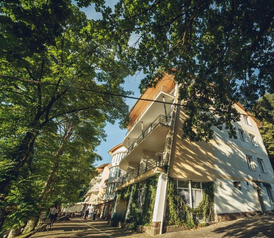 een groot wit gebouw aan de straatkant bij Готель Поляна Квеле in Polyana