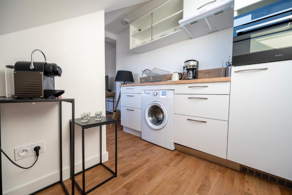 a kitchen with a washing machine and a washer at Le Poulorio 12 - T2 - Proche Gare - dernier étage By Locly in Lorient