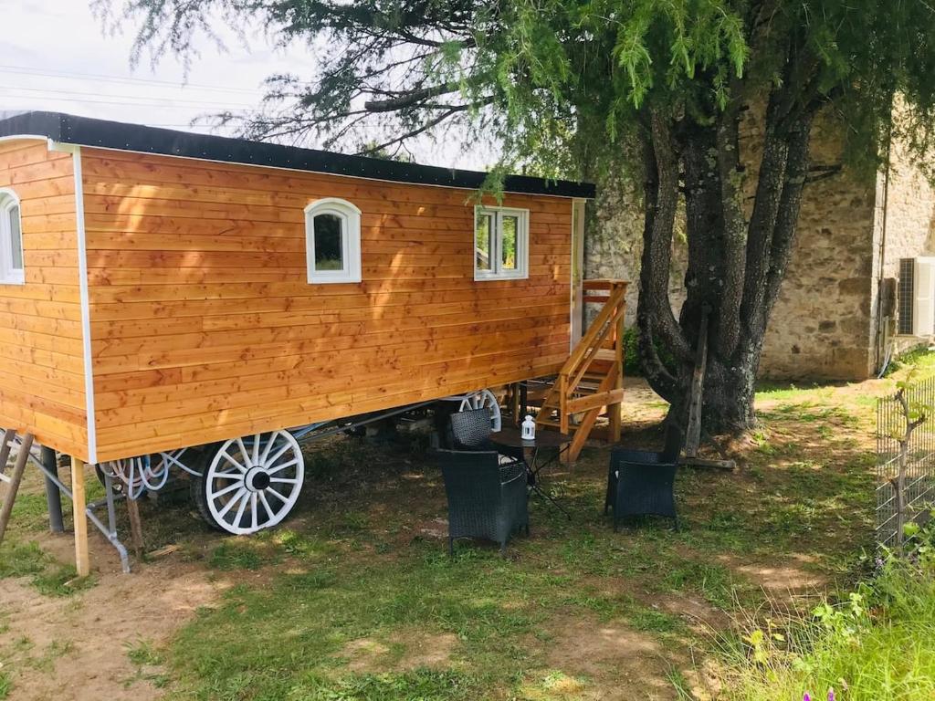 a tiny house on a wagon in a yard at ROULOTTE DE CHARME in Saint-Genest-de-Bauzon