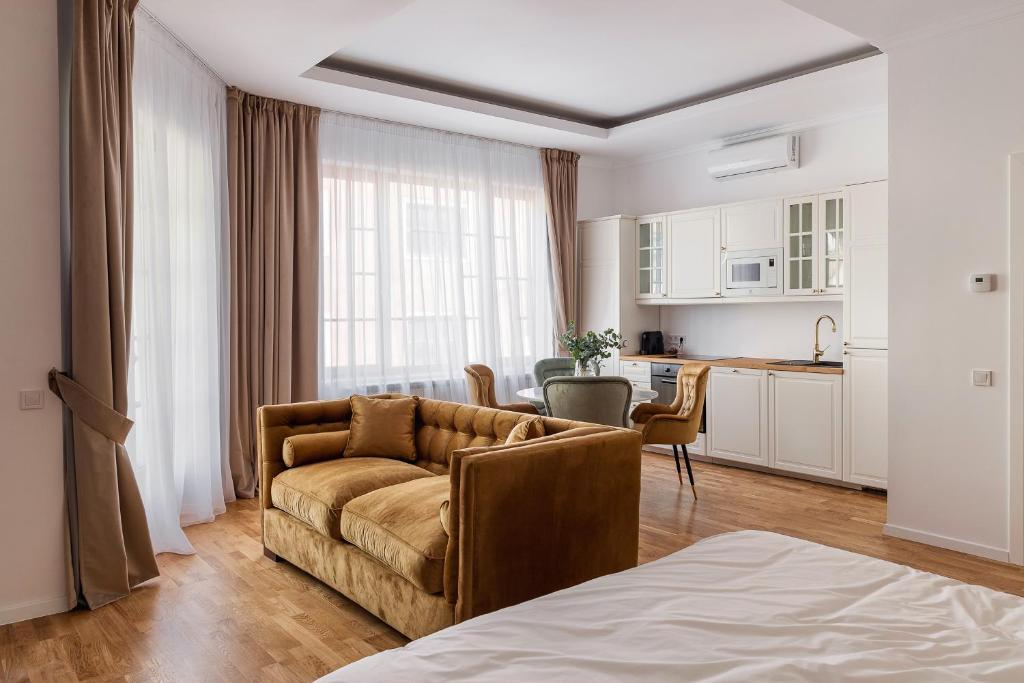 een woonkamer met een bank en een keuken bij CLUJ-NAPOCA coeur de ville in Cluj-Napoca