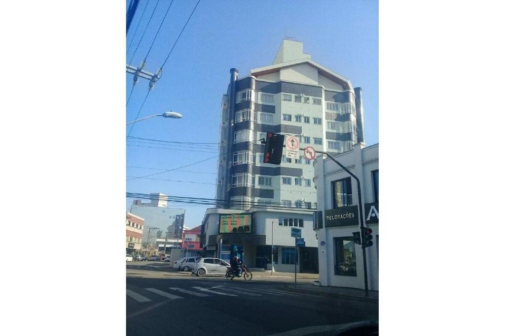 a tall building on a city street with a traffic light at Apartamento no Centro de Brusque/SC in Brusque