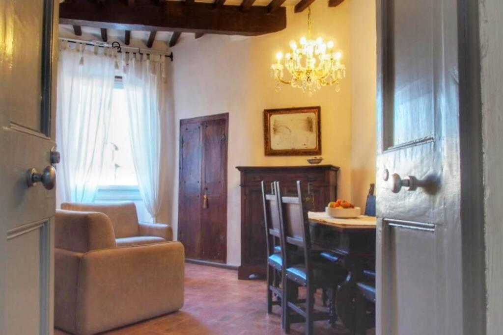 un soggiorno con tavolo, sedie e lampadario pendente di L'angolo di Zia Anna a Montefalco