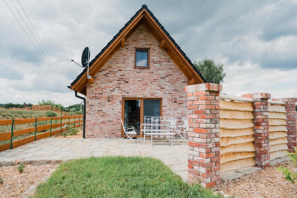 Cette maison en briques dispose d'une terrasse et d'une clôture. dans l'établissement Tatarska Zagroda - Agroturystyka Dolina Baryczy Noclegi - Domek Danielek, à Krośnice