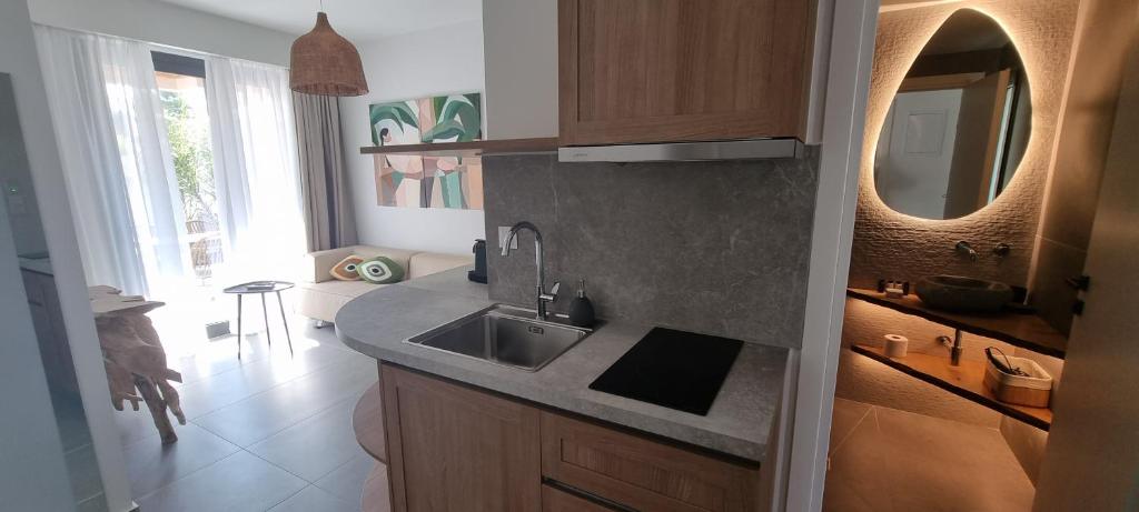 a kitchen with a sink and a mirror at Olvion Luxury Living in Kallithea Halkidikis