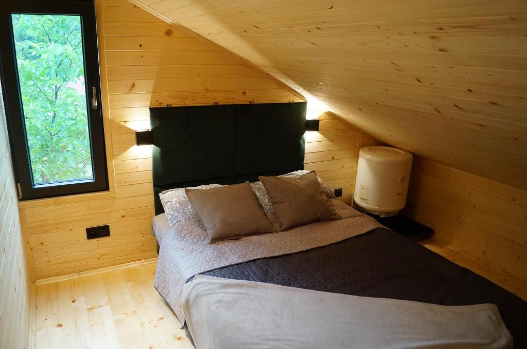 SułoszowaにあるMały domek w Dolinie Prądnikaの木造キャビン内のベッド1台が備わるベッドルーム1室を利用します。