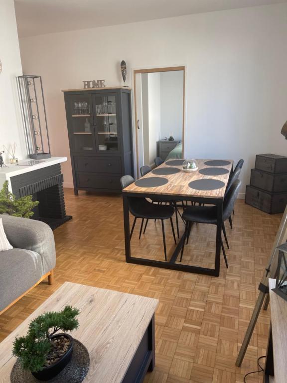 sala de estar con mesa y sofá en Appartement…LH center / 6 pers. parking privé, en Le Havre