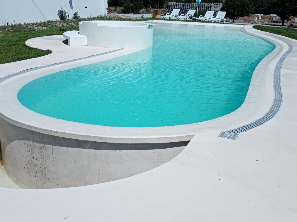 a swimming pool with blue water in a backyard at Moradia Vila Rosa in Ponte de Vagos
