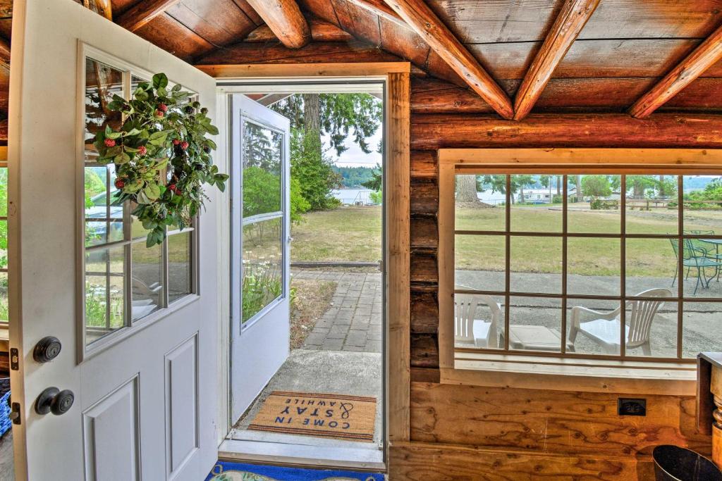 an open door in a log home with windows at Historic Belfair Cabin Abode on the Hood Canal! in Belfair