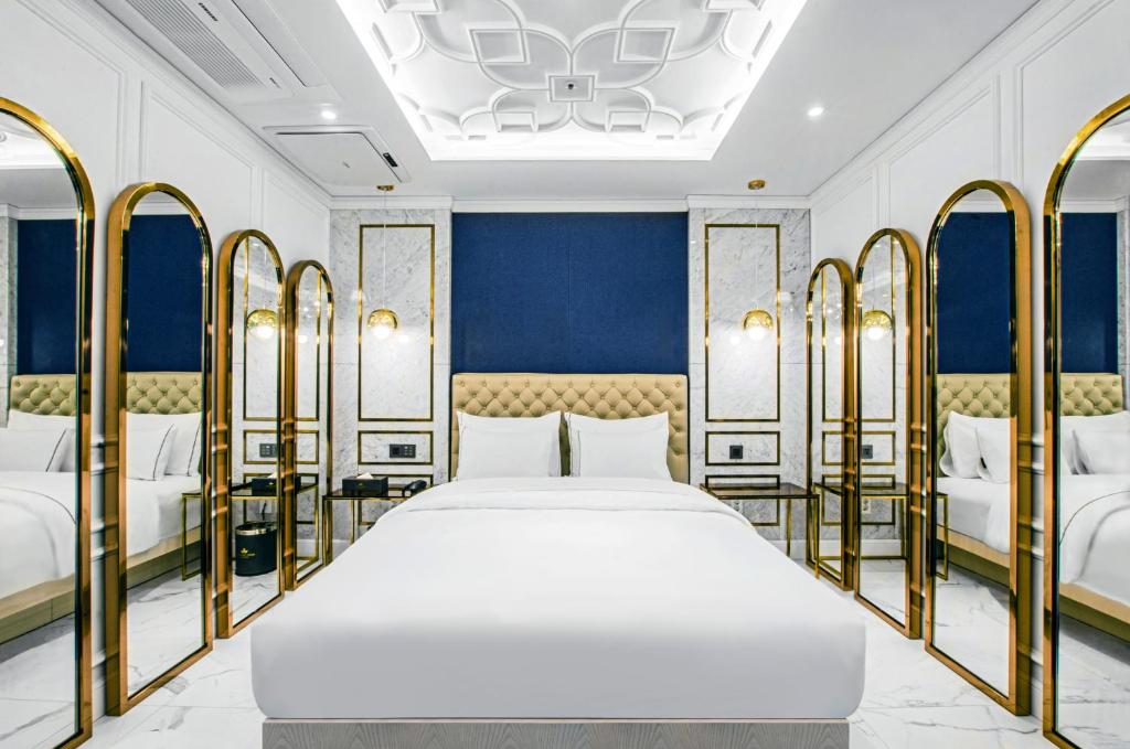 Hotel the Castle bangi 2nd في سول: غرفة نوم بسرير كبير اطارات ذهبية