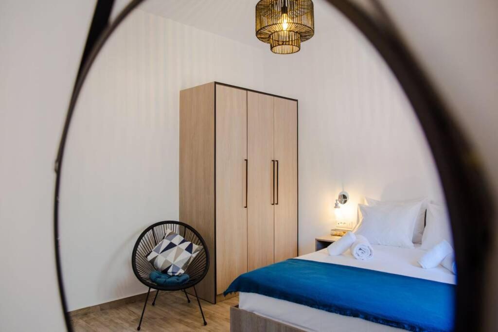 una camera con letto, sedia e specchio di Potnia House in the center of Rhodes a Città di Rodi