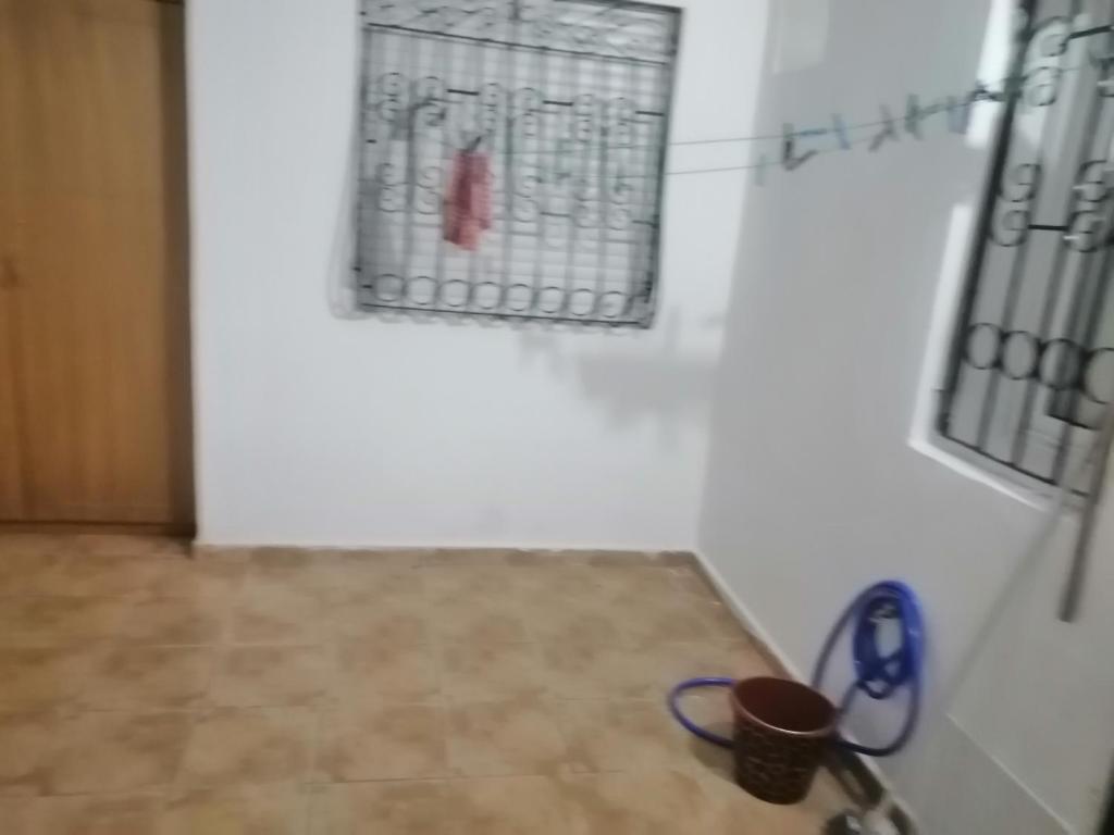 una habitación con una pared blanca y una puerta con tijeras en Sweet appartement Gigi en Tetuán