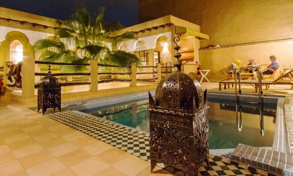 une maison avec une piscine et une maison avec un palmier dans l'établissement Riad Benyara, à Taroudant