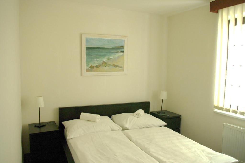 a bedroom with a bed with white sheets and a picture at Hotel Širák in Most