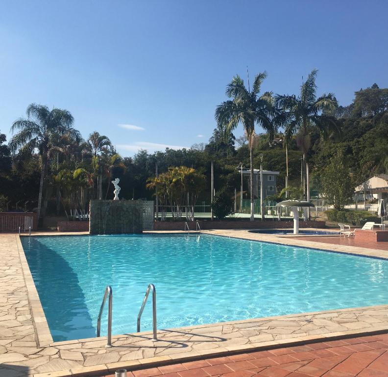 una gran piscina con una fuente y palmeras en Apart-Hotel Cavalinho Branco (311 e 409 ), en Águas de Lindóia