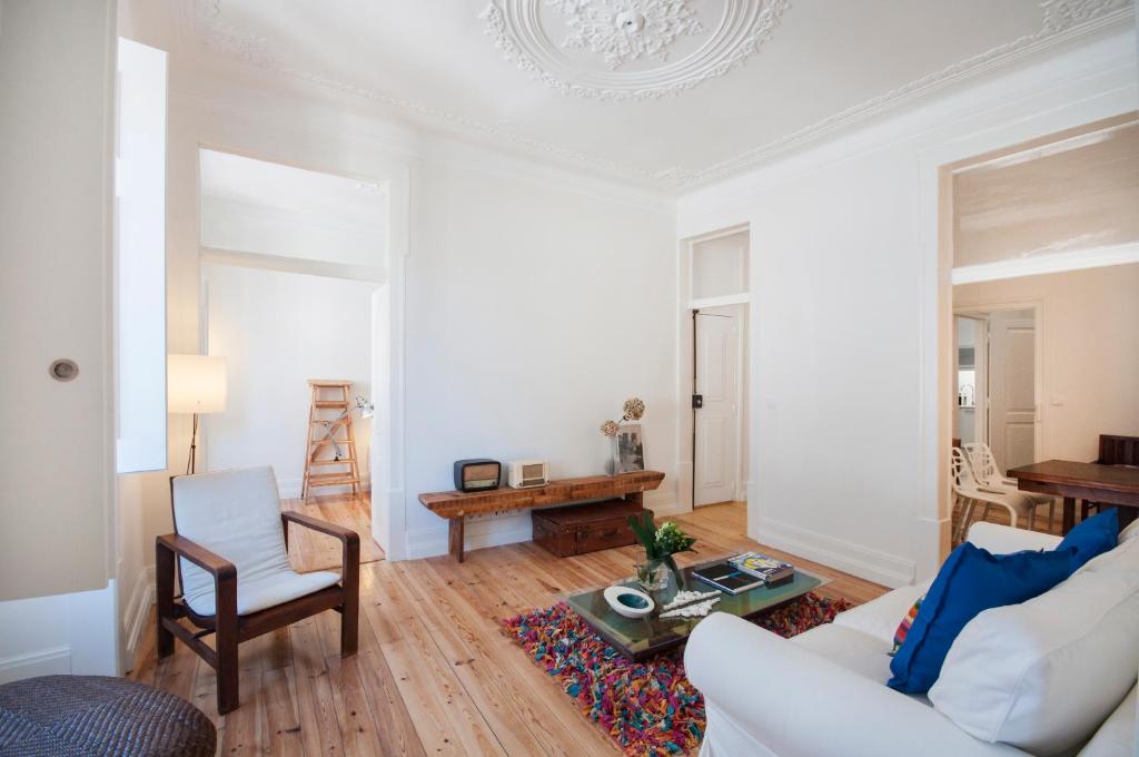 - un salon avec un canapé blanc et une table dans l'établissement Alfama - Sé Cathedral | Lisbon Cheese & Wine Apartments, à Lisbonne