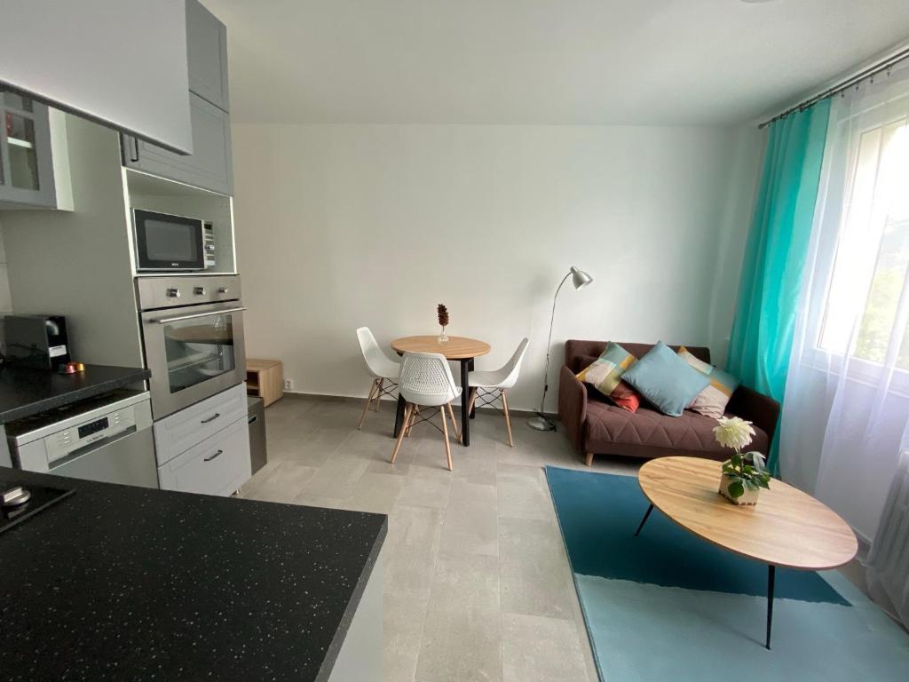 een keuken en een woonkamer met een bank en een tafel bij NOVÝ HORSKÝ APARTMÁN v Jizerských Horách in Hejnice