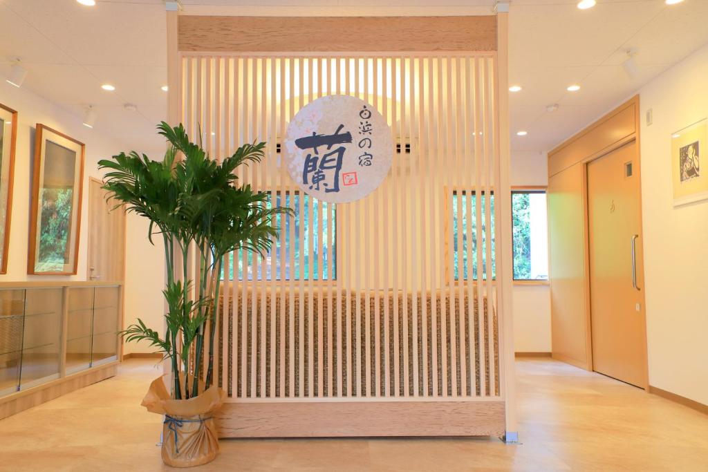 um átrio com uma parede com uma planta num quarto em 白浜の宿　 蘭 em Shirahama