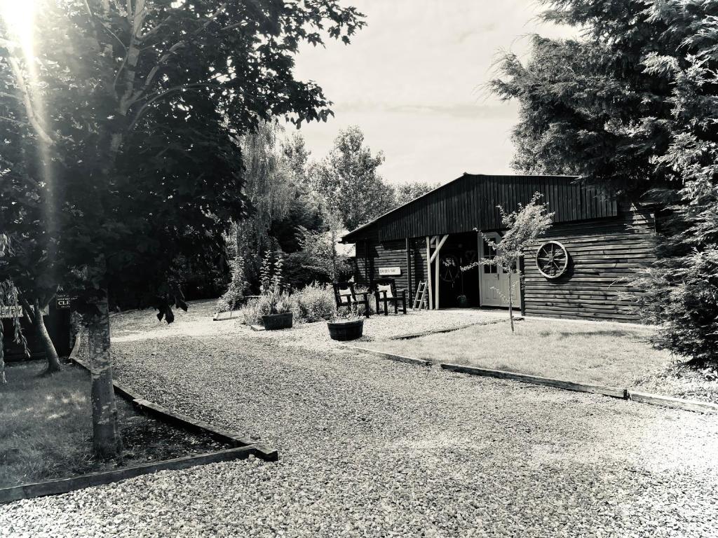a black and white photo of a log cabin at Alfie Acres - Secluded Cabin set in 5 Acres of Privacy, with Exclusive use of Swimming Pool and Hot Tub for up to 10 Guests in Downham