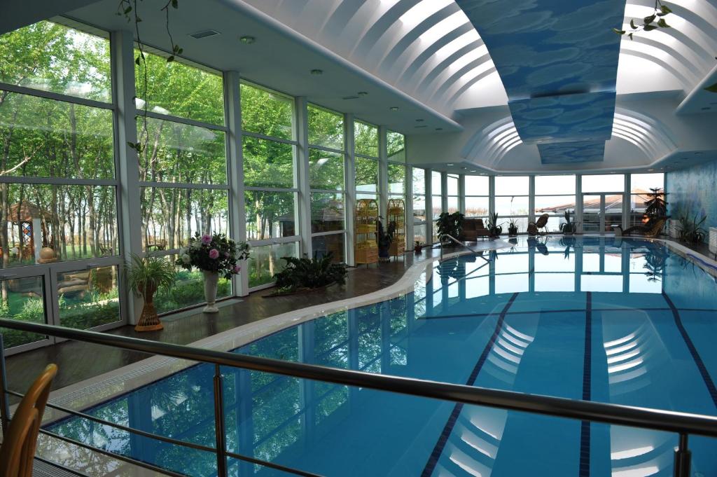 una gran piscina cubierta con un gran techo y ventanas en Вязовая Роща Апарт-отель, en Orlovka