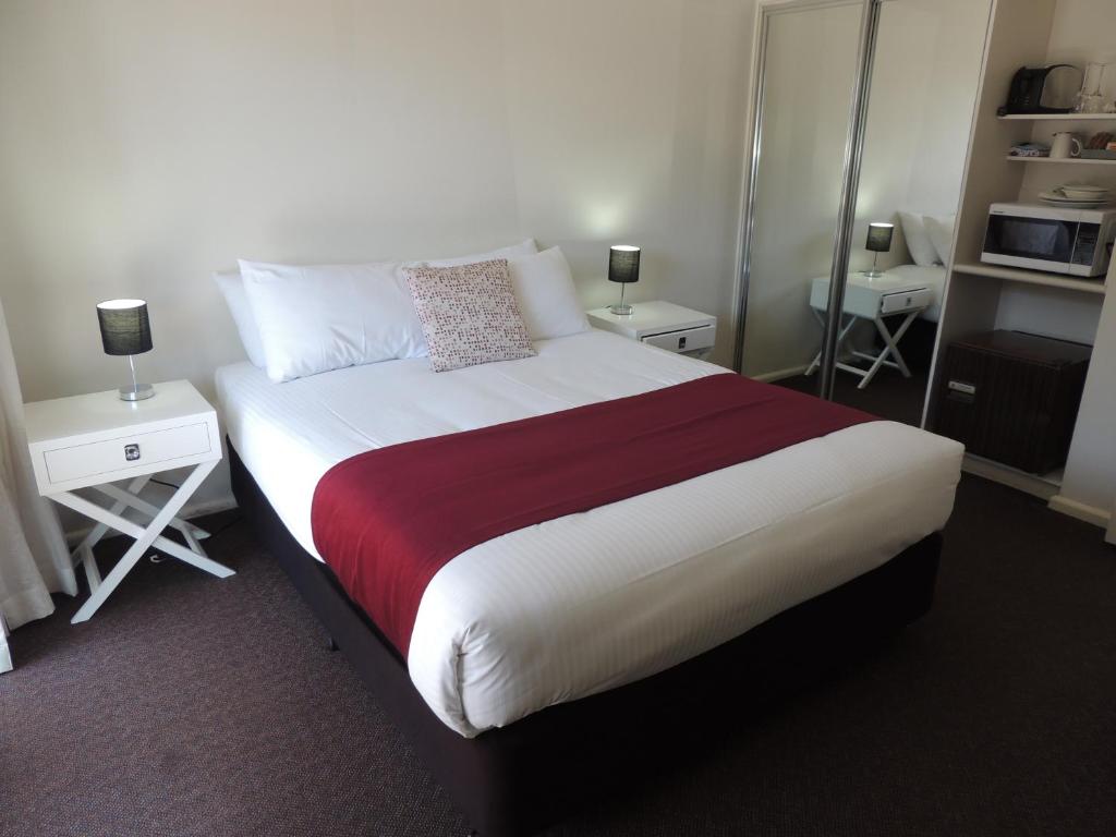 a bedroom with a large bed with two night stands at Comfort Inn Premier in Coffs Harbour
