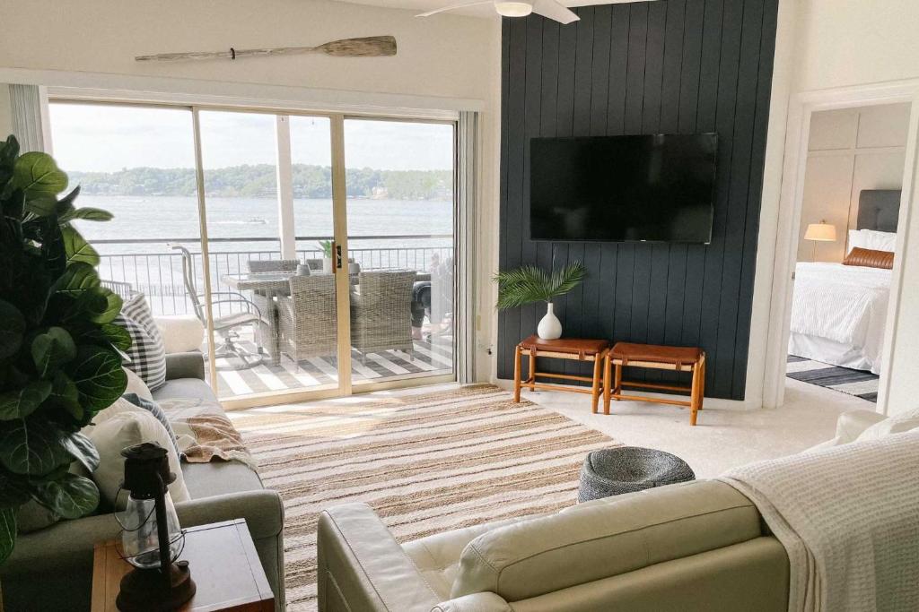 uma sala de estar com um sofá e uma televisão em Waterfront Condo with 2 Pools and Boat Slip! em Lake Ozark