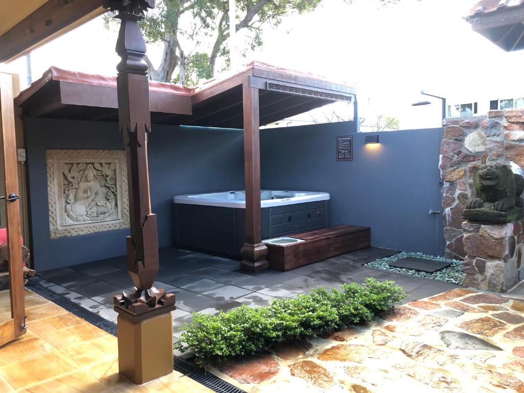 een badkamer met een bad in een blauwe muur bij Bali at the Bay in Nelson Bay