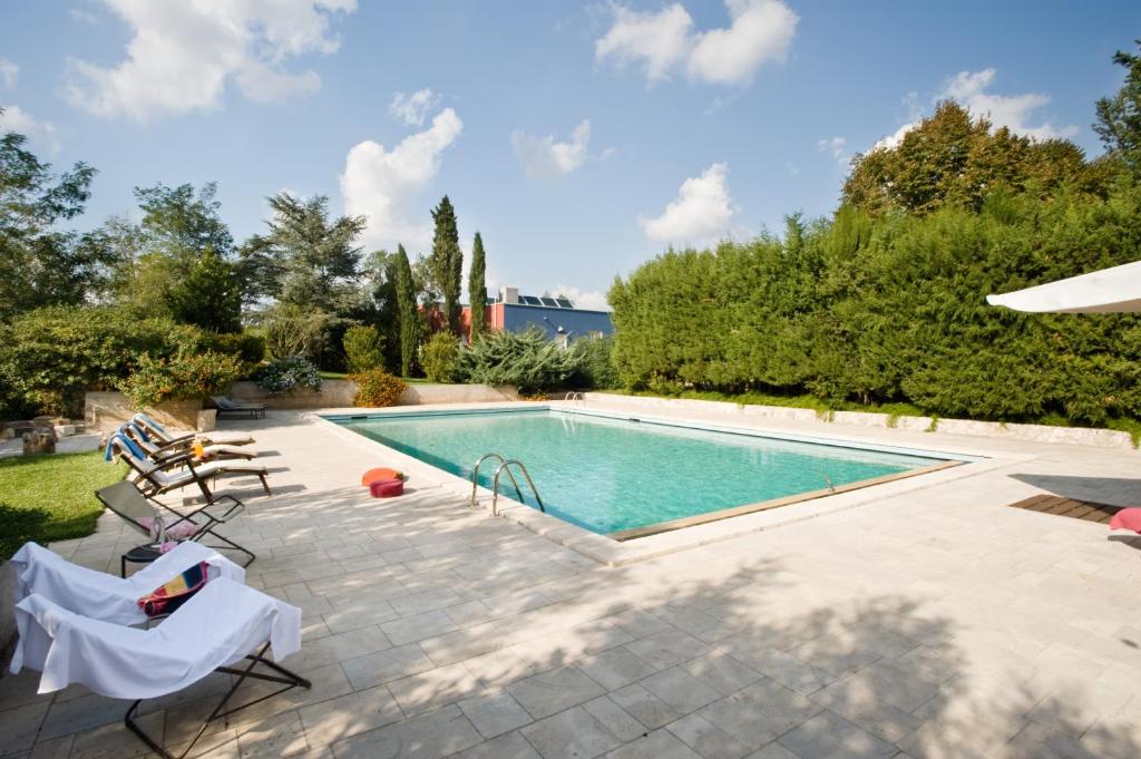 a swimming pool in a backyard with chairs around it at Agricola Samadhi in Zollino