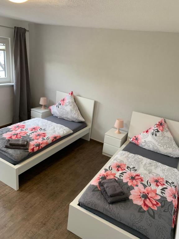 a bedroom with two beds and two night stands at Vina am ring Apartment in Mannebach