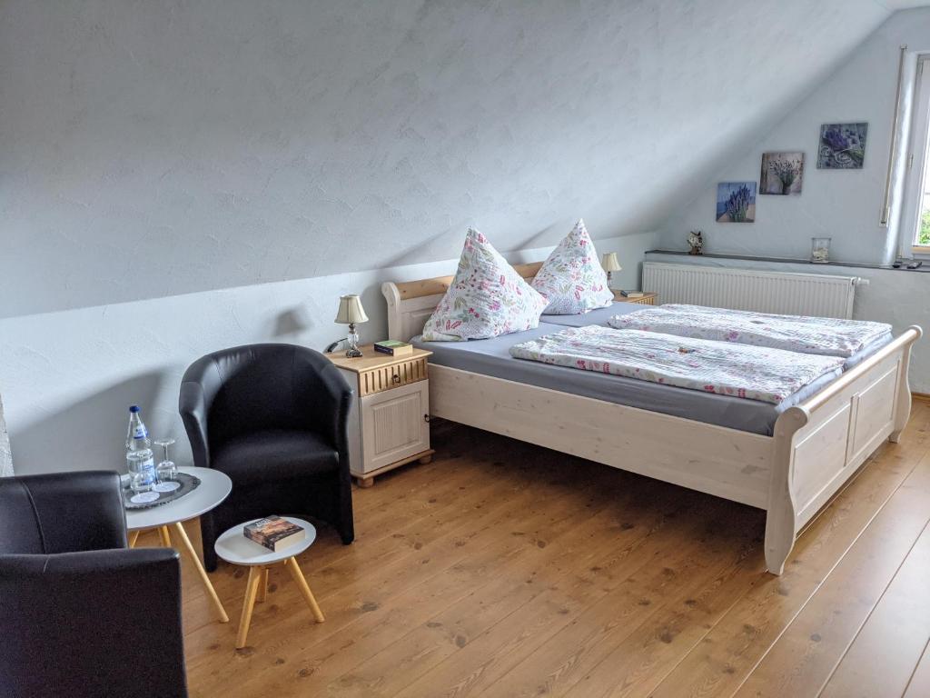 a small bedroom with a bed and a chair at Gaestehaus Gaes in Trittenheim