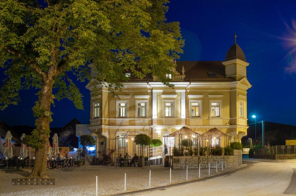 um grande edifício com uma árvore em frente em Dvorec Gregorčič em Smarjeske Toplice