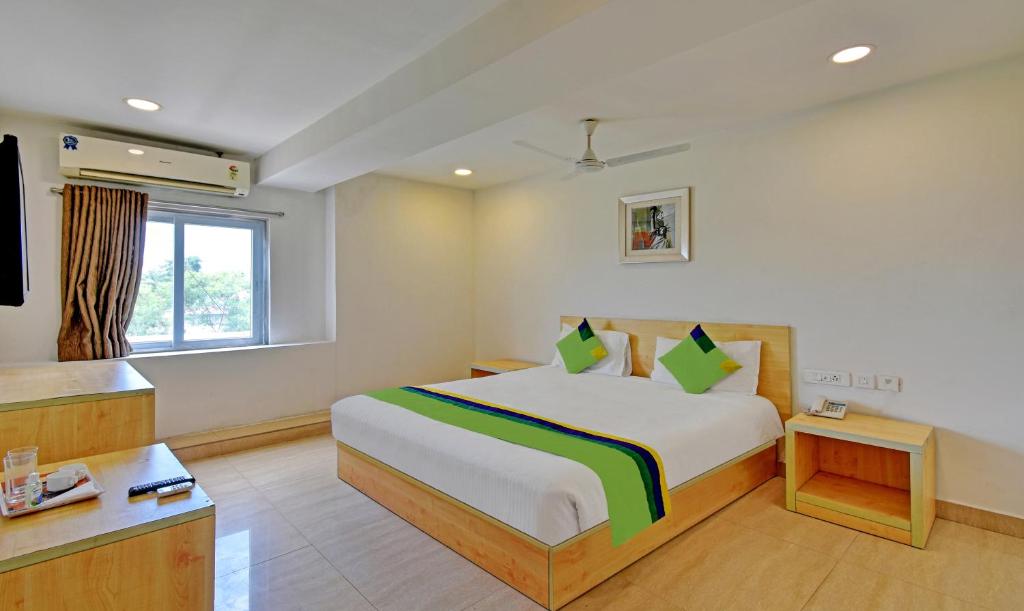 Habitación de hotel con cama y TV en Treebo Trend Innside en Chennai