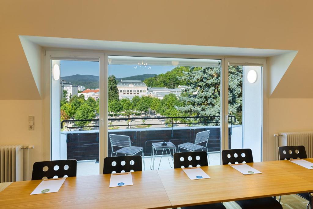 a conference room with a table and a large window at At the Park Hotel in Baden
