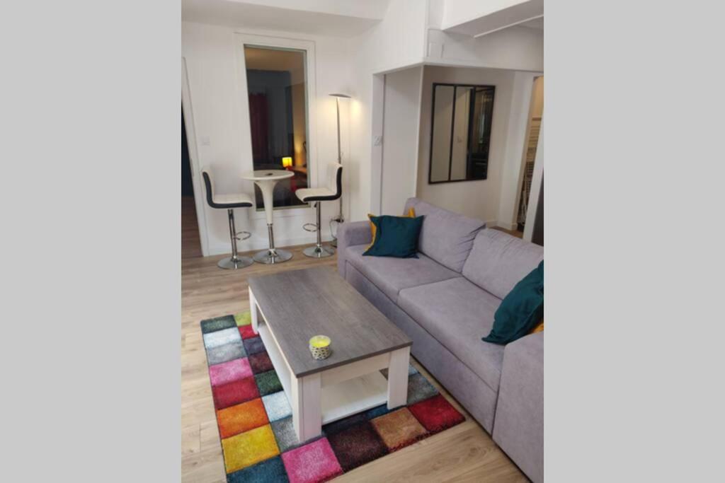 ein Wohnzimmer mit einem Sofa und einem Tisch in der Unterkunft Clos Saint Jacques in Thann