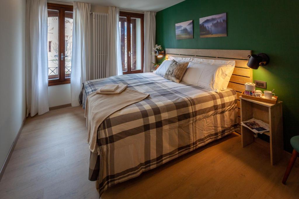 um quarto com uma cama com uma parede verde em Il Fauno em Asiago