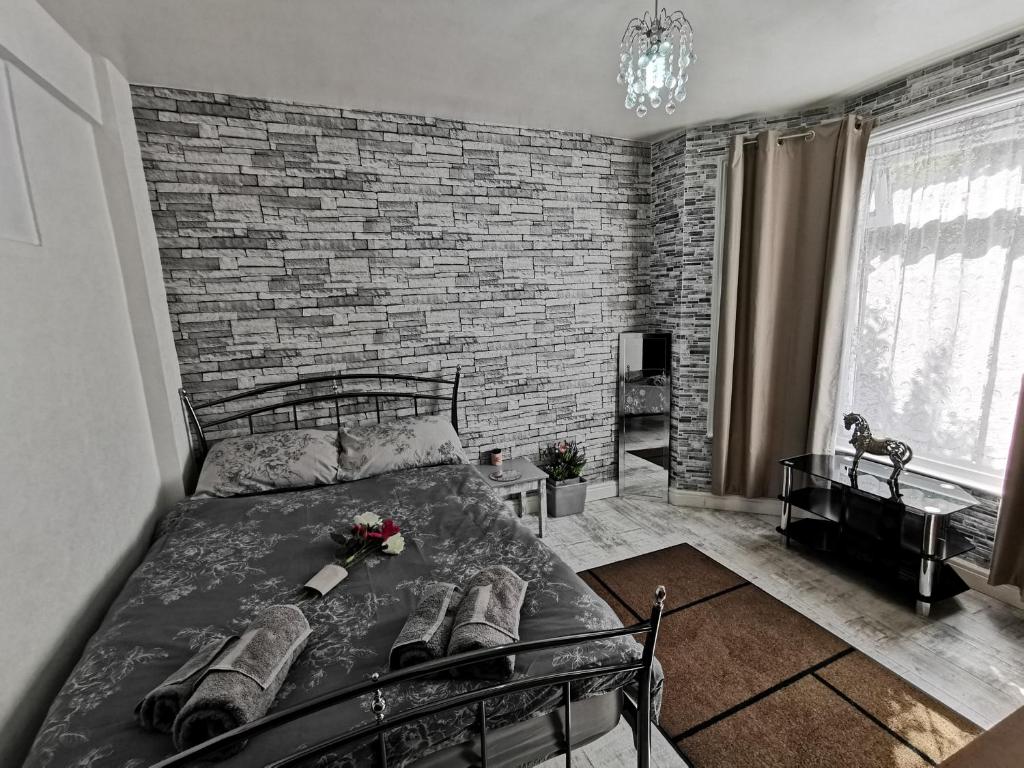 a bedroom with a brick wall and a bed at Palaz 3 - 1 Bedroom Flat-Apartment in Edmonton