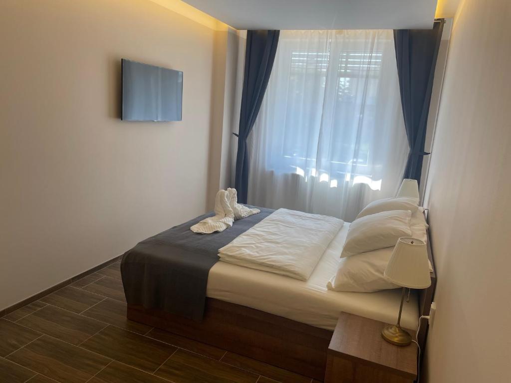 Dormitorio pequeño con cama y ventana en MP hotel en Znojmo