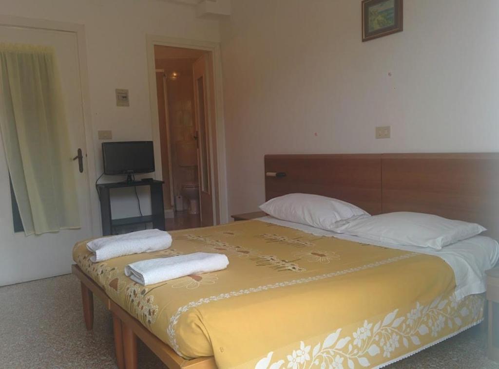 a bedroom with a bed with two towels on it at PENSIONE GARDENIA in Finale Ligure