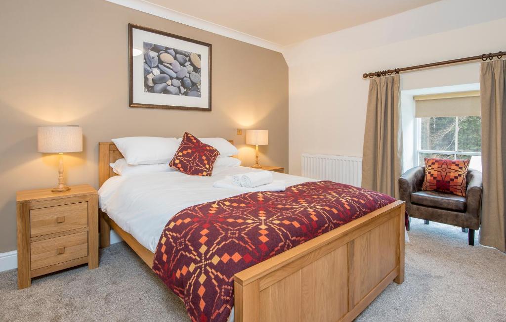 a bedroom with a bed and a chair and a window at The Nags Head Inn in Abercych