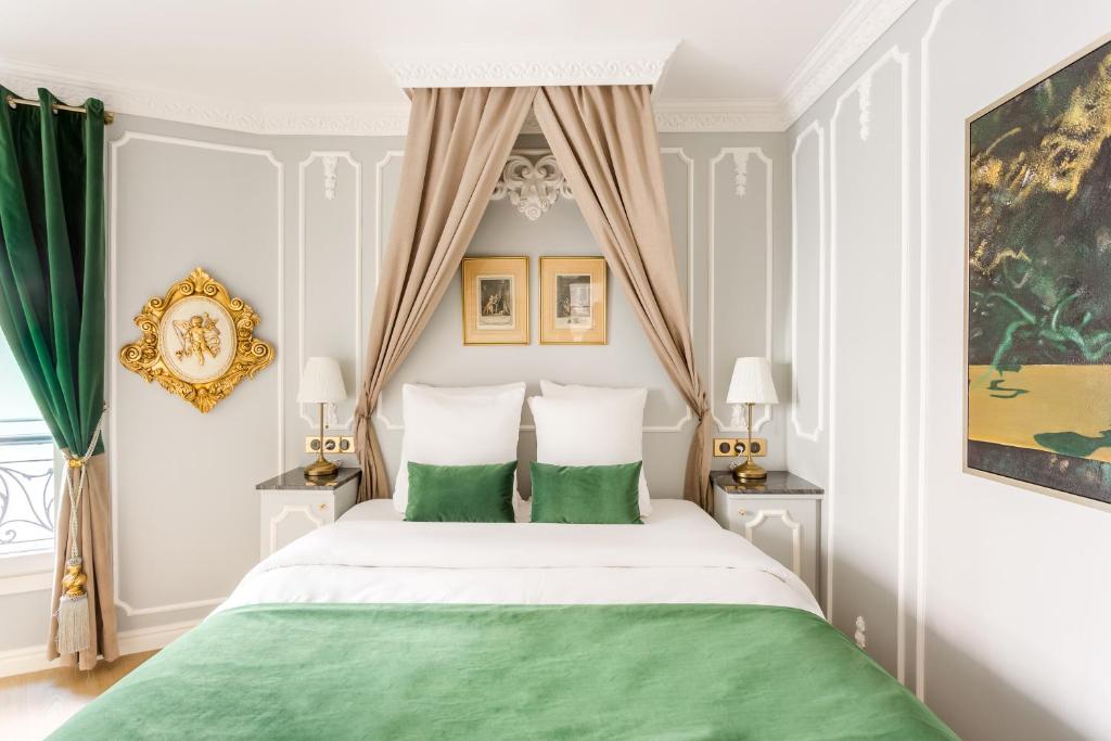a bedroom with a large bed with green pillows at Luxury 2 Bedroom 2,5 Bathroom Apartment - Champs Elysees in Paris