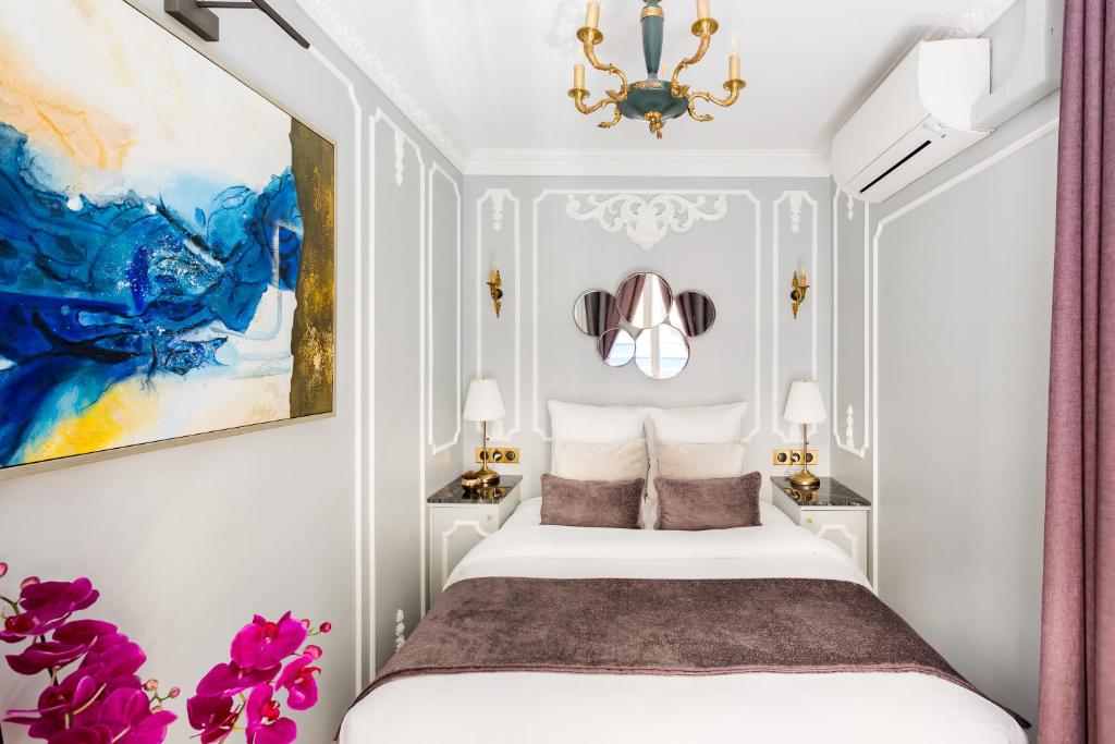 a bedroom with a white bed and a chandelier at Luxury 2 Bedroom 2,5 Bathroom Apartment - Champs Elysees in Paris