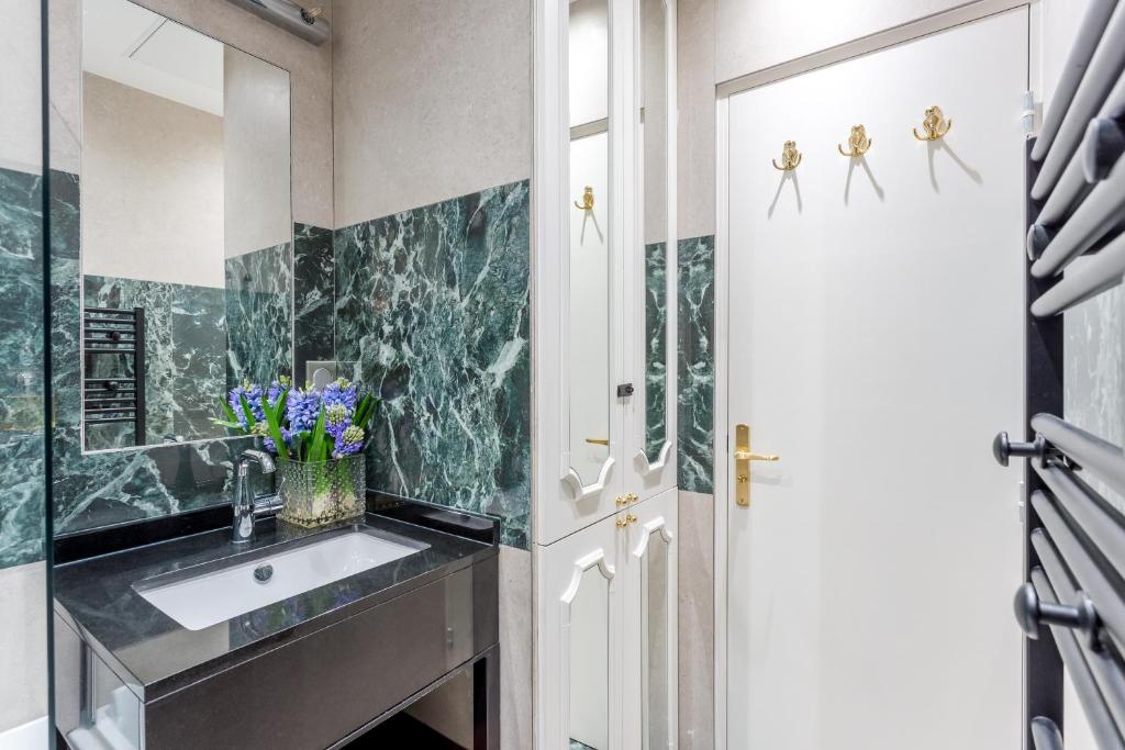 a bathroom with a sink and a mirror at Luxury 2 Bedroom 2,5 Bathroom Apartment - Champs Elysees in Paris