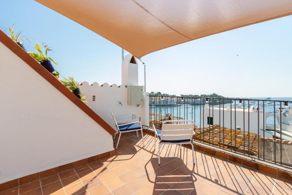 a balcony with chairs and a view of the ocean at Apartaments Bellaire Cadaqués in Cadaqués