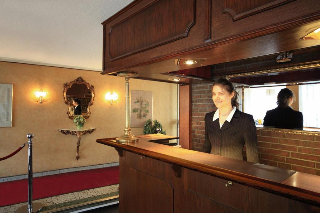 a woman standing behind a bar in a restaurant at Hotel Lafayette in Hamburg