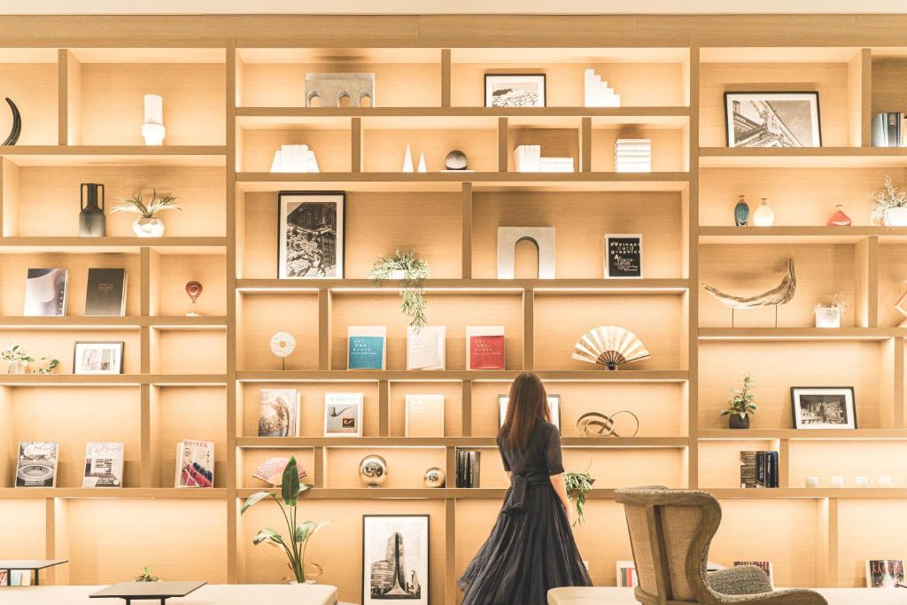 a woman standing in front of a book shelf at Nikko Style Nagoya in Nagoya