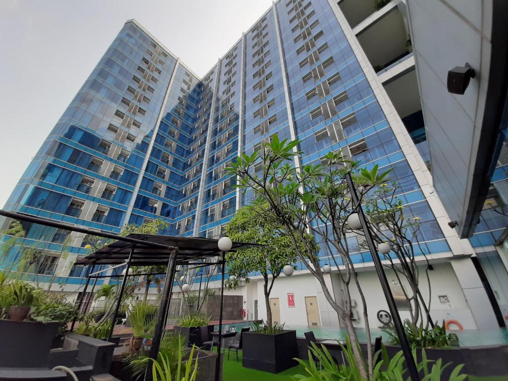 two tall buildings with plants in front of them at Cozy Tamansari Hive Cawang by Bonzela Property in Jakarta