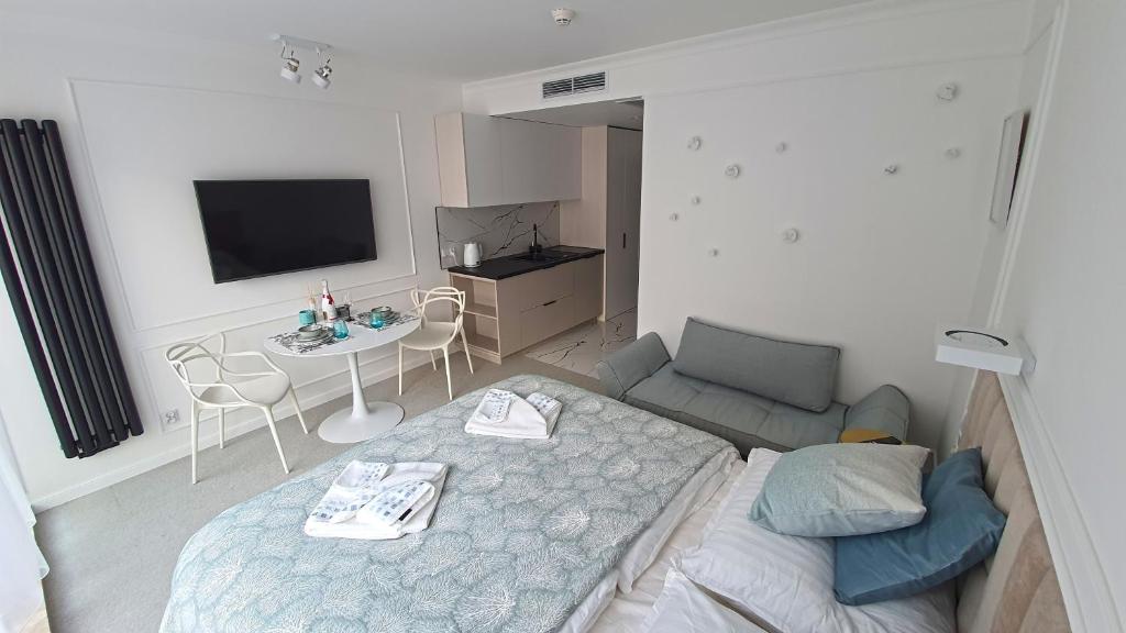 a room with a bed and a table and a tv at Lividus 432 By Edyta in Świnoujście