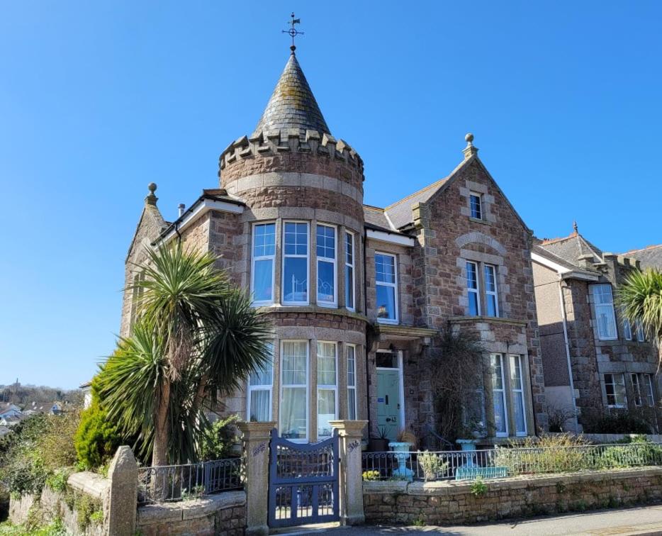 a large brick house with palm trees in front of it at Lansdowne Simply Stay in Redruth